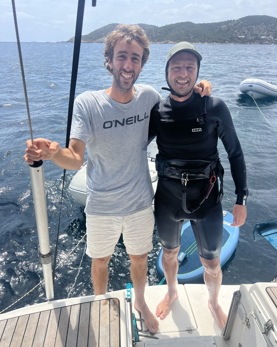 Dos riders sonriendo en la proa del catamarán