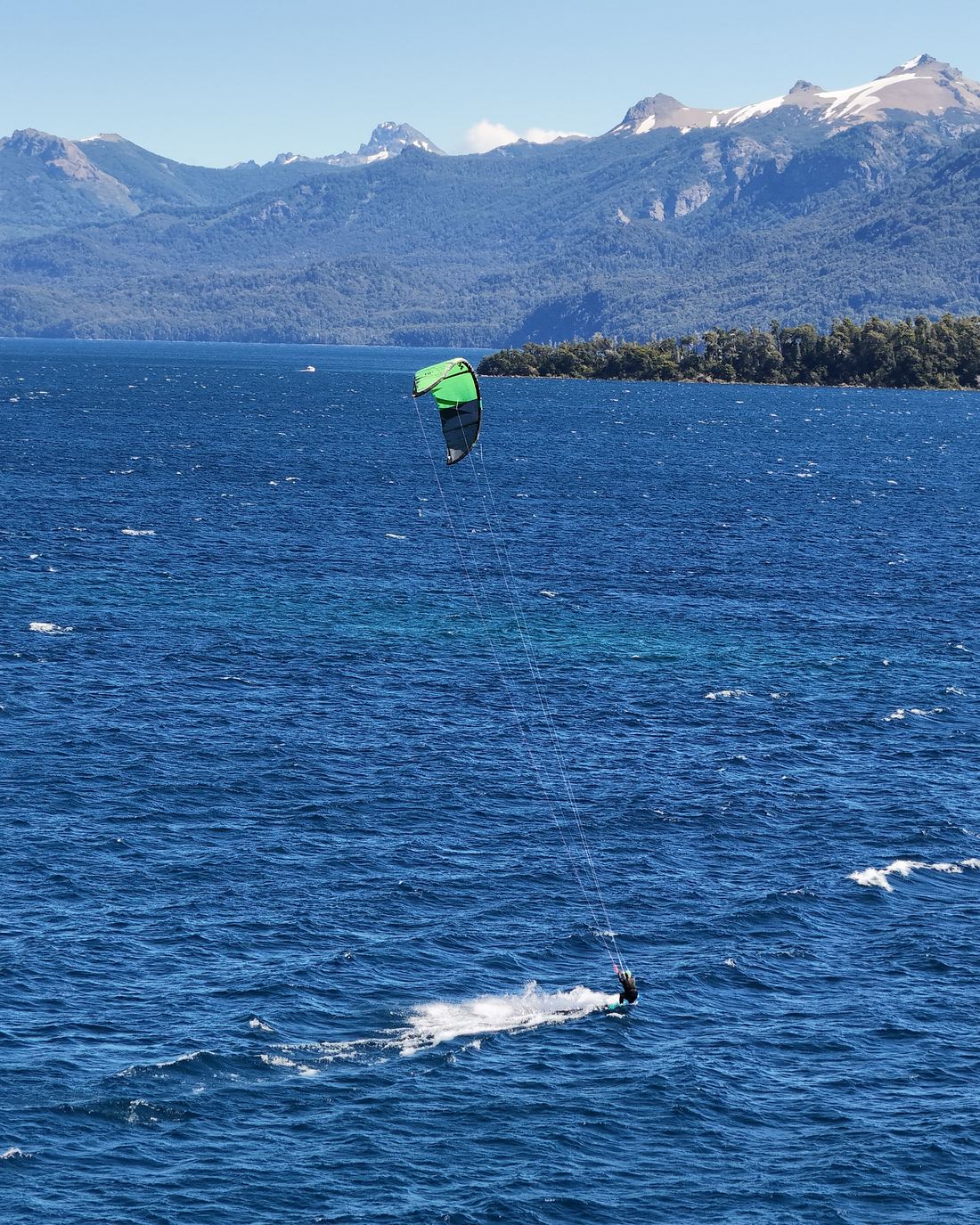 Kitesurf en un lago de Patagonia con la cordillera nevada de fondo