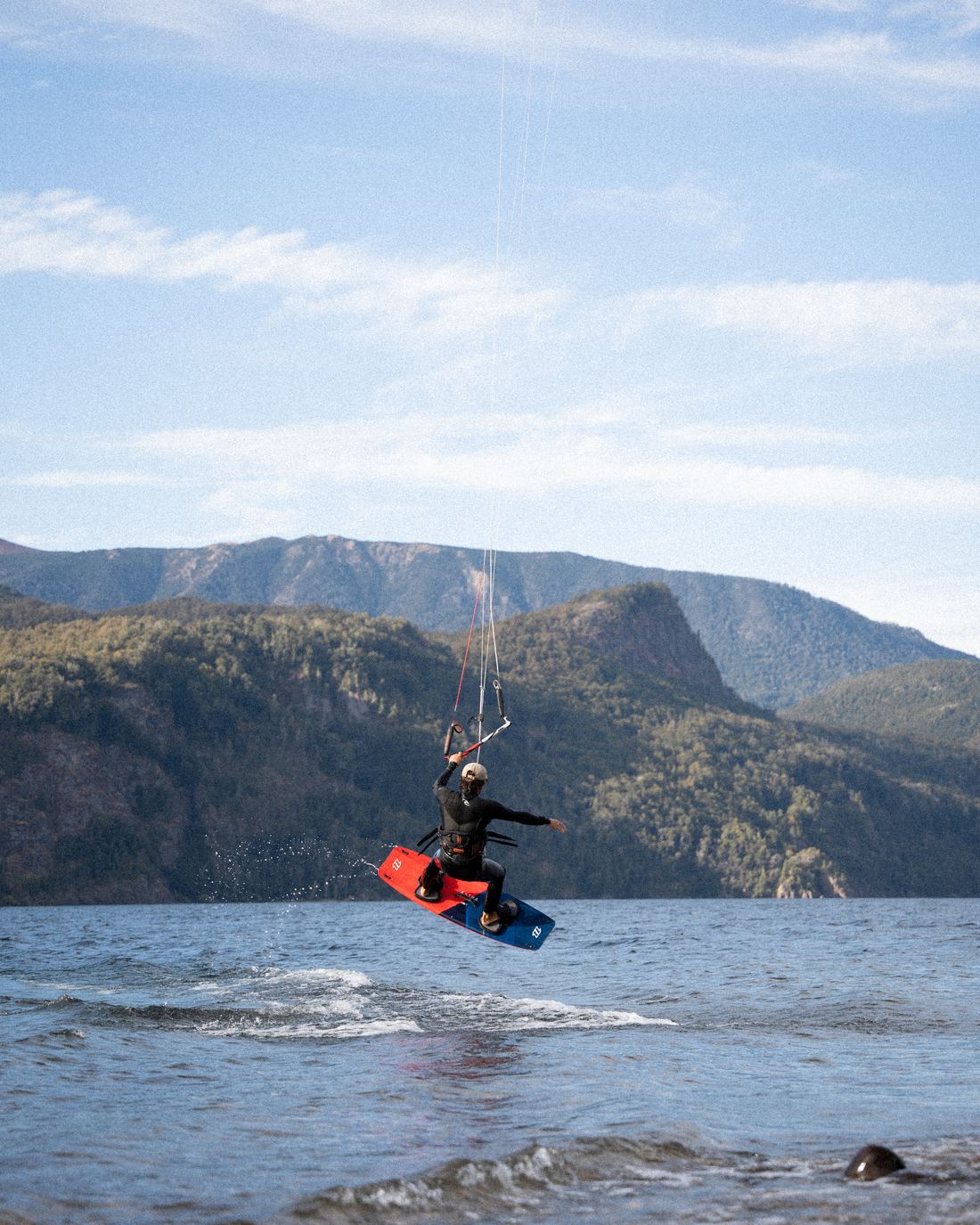 Salto de kite en el lago Lácar con la cordillera de fondo